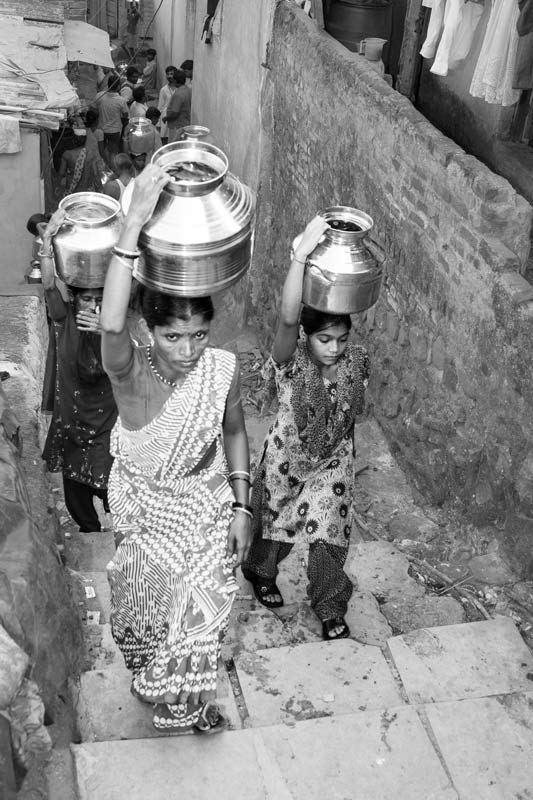 Human Right to Water in India - Urban women and girls fetching water from a distance more than 100 m, carrying headloads over steep stairs in Mumbai, Maharashtra